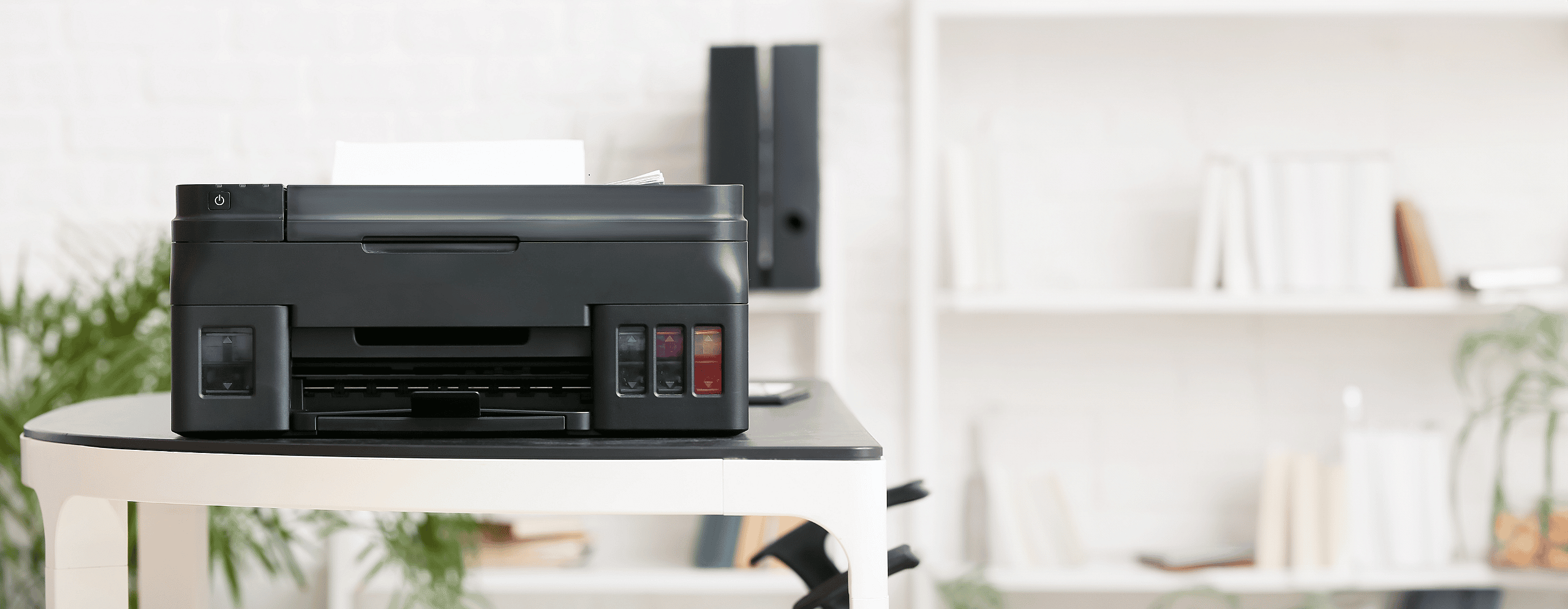 Black printer on a table in an office environment, showcasing grenke's flexible leasing options for laser, LED, multifunction, and 3D printers, helping businesses stay connected and competitive with strategic financing solutions.